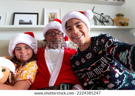 Funny moment in family. Two children and their grandfather taking a self portrait at Christmas time.