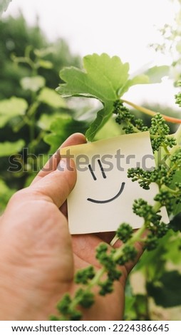 small sign with a happy face emoticon sticker think green among the plants defending the environment and the planet