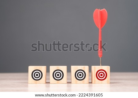 Red dart hit the only wood cube with different red target symbol, narrow the target, target audience, marketing campaign Royalty-Free Stock Photo #2224391605