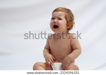 The baby is 10 months old crying . Teeth or tummy hurt. The concept of medical care for a child . Beautiful red hair little girl . Motherhood and childcare  Royalty-Free Stock Photo #2224396335