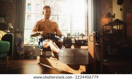 Strong Athletic Black Man Does Shirtless Workout at Home Gym, Exercising on stylish Water Rowing Machine. Lean Fit Muscular Mixed Race Sportsman Staying Healthy, Training. Sweat and Determination. Royalty-Free Stock Photo #2224406779