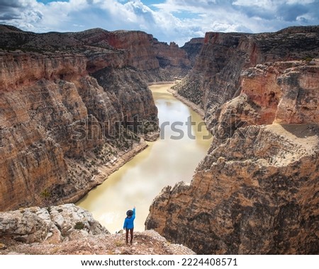 A woman on the edge of the cliffs at Bighorn Canyon National Recreation Area in Montana Royalty-Free Stock Photo #2224408571
