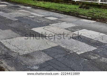 Extremely bad quality road with many patches, potholes Royalty-Free Stock Photo #2224411889