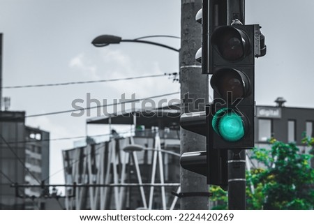Traffic semaphore with green light in an urban area with a couple of building behind