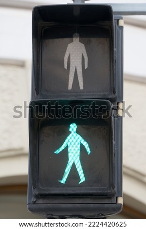 Close up of green pedestrian figure a traffic light as a concept for start release approval and departure