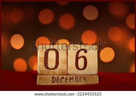 December 6 vintage wooden block calendar on red fabric, festive bokeh lights background greeting card celebrating holidays, birthday, save the date for special occasion. Royalty-Free Stock Photo #2224433525