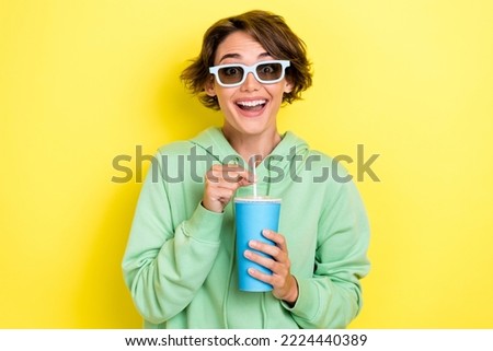 Photo portrait of nice young woman hold plastic cup drinking sunglass freak wear trendy green clothes isolated on yellow color background