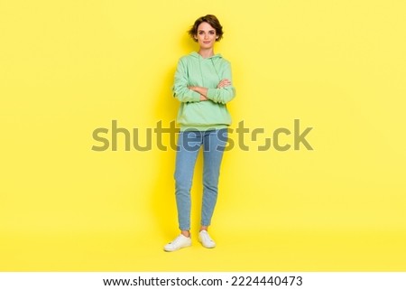 Full length photo of charming confident girl dressed green sweatshirt arms crossed smiling isolated yellow color background Royalty-Free Stock Photo #2224440473