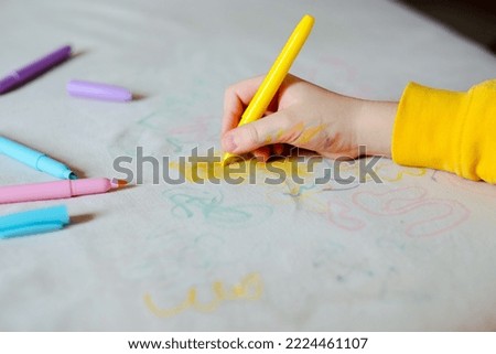 The child hand drawing with felt-tip pen on the upholstery of the couch. Furniture fabric. Cleaning concept Royalty-Free Stock Photo #2224461107