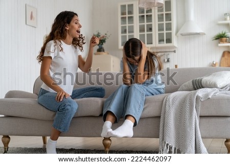 Mother yelling at her daughter teenage girl, parent losing control getting angry, emotional furious young woman mom reacting to adolescent problem behavior, screaming at kid covering ears with hands Royalty-Free Stock Photo #2224462097