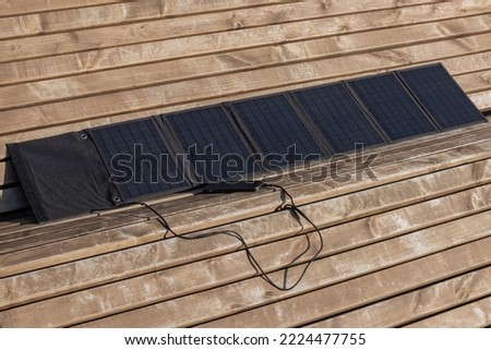 Mobile phone is charged by solar panel. Camping solar panel.