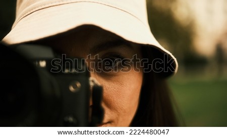 The girl looks into the camera lens with one eye