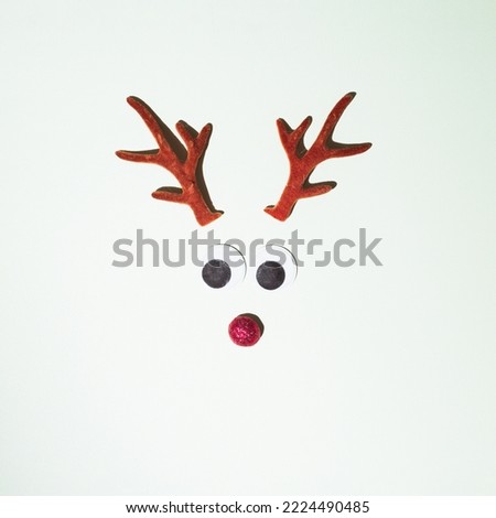 Reindeer horns placed on a white background. Winter idyll concept. New Year's set and red nose decoration.