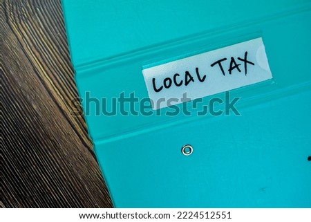 Concept of Local Tax write on the piece of paper isolated on Wooden Table.