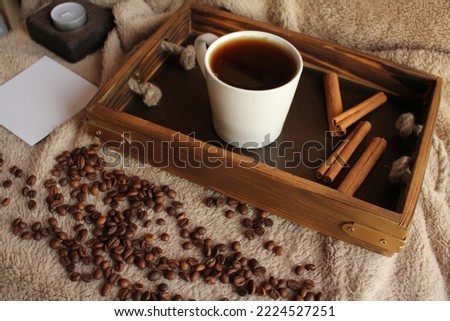 Morning coffee. Morning at home. On the table are coffee grains, a wooden tray, a notepad, a business card holder. Free space for recording.