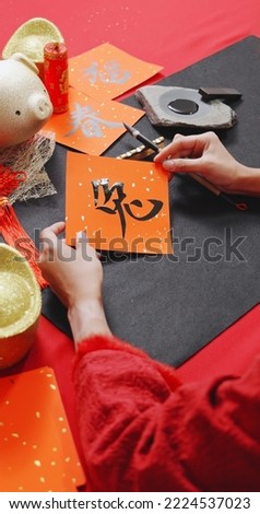 top view of asian woman finish writing spring festival couplet to celebrate Chinese new year with word meaning Rabbit Royalty-Free Stock Photo #2224537023
