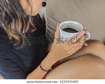 A young woman drank a glass of coffee on the sofa while relaxing. Christmas and New Year holidays