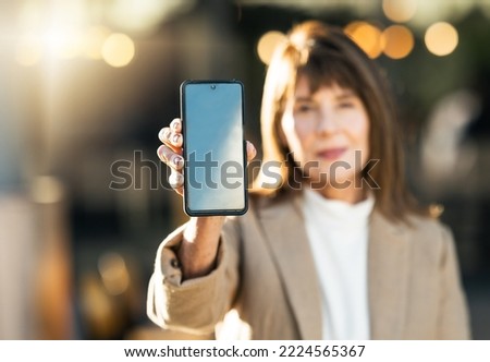 Woman, hand and phone mockup on bokeh background for mobile advertising, marketing or sale in the outdoors. Hands of female showing wireless technology smartphone for communication on blue chromakey