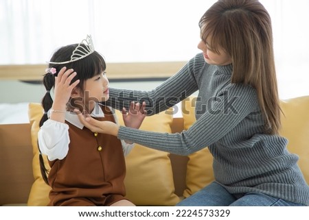 Happy loving family. Asian mother and her daughter child girl playing in bedroom. Role-play little princess. Royalty-Free Stock Photo #2224573329