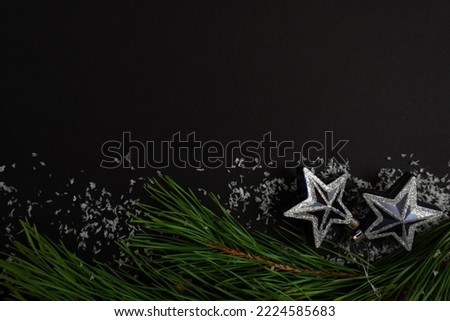 beautiful black christmas background for postcards, flyers, banners. Christmas tree branch and Christmas balls and toys                          