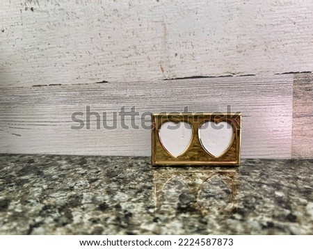 Tiny gold colored heart shaped picture frame.