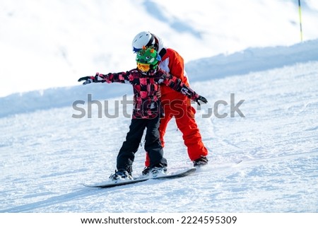 Snowboard School. Boy with Instructor Learning Snowboarding. Royalty-Free Stock Photo #2224595309