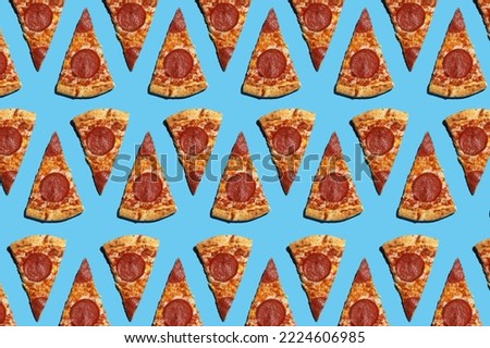A hard light pattern of cut salami pizza pieces on a seamless bright blue background, top view