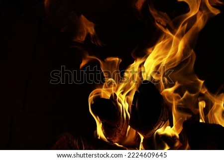 Background of the flame in the oven. Tongues of fire in brick fireplace. Fire texture.