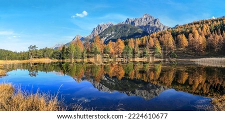 Panorama of the Swiss Alps mountain lake Lai Nair (Black Lake) with refleciton of autumn forest on the hiking trail at Scoul Tarasp, Lower Engadin, Switzerland Royalty-Free Stock Photo #2224610677