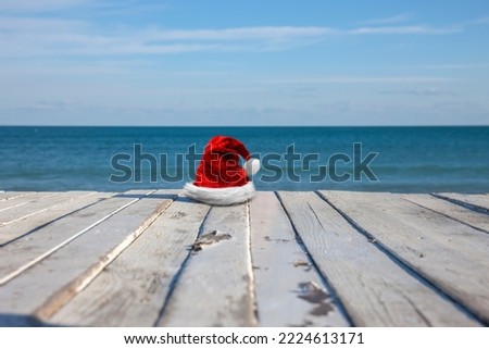 Christmas hat on wooden terrace with sea in background