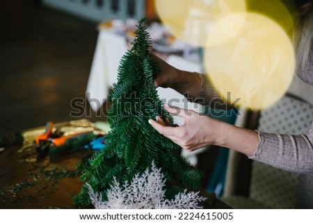 Craft from a live coniferous branch. Christmas tree hand made of natural nobilis. Close-up of hands. New Year's Eve master class on creating decorations from natural nobilis. DIY.