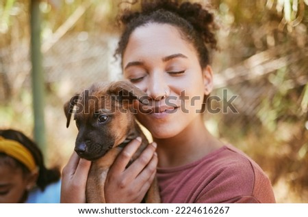 Love, dog and animal shelter with a black woman hugging a foster pet while at a shelter to adopt a rescue animal. Volunteer, charity and adoption with a female holding a cute puppy at the pound Royalty-Free Stock Photo #2224616267
