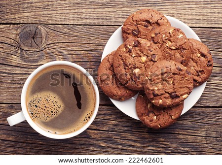 Plate with chocolate cookies and cup of hot coffee on old wooden table. Top view Royalty-Free Stock Photo #222462601