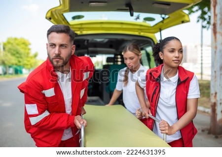 young paramedics moving ambulance stretcher from car in a hurry. Paramedics in uniform taking stretcher out the ambulance car Royalty-Free Stock Photo #2224631395