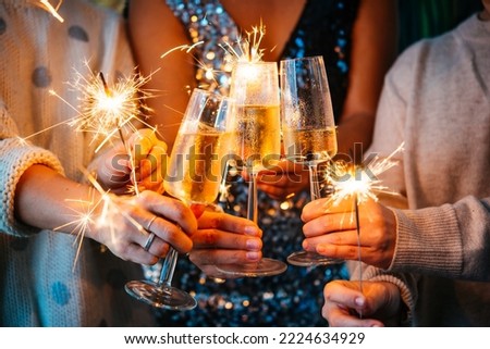 Friends celebrating Christmas or New Year's eve with Bengal lights and champagne.


 Royalty-Free Stock Photo #2224634929