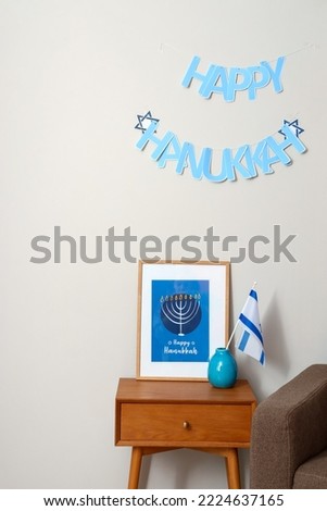 Table with picture, Israel flag and text HAPPY HANUKKAH on light wall