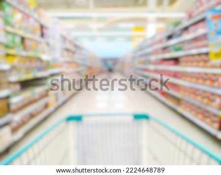 Blurred bokeh products on the shelves of supermarket malls or shopping centers with shopping cart.