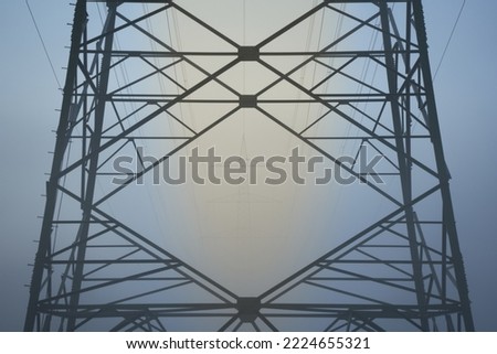Detail from a Electricity pylon (Strommasten) also overhead line pylon in foggy Winter morning. Front View.