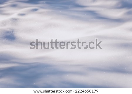 White snow in sunlight on a clear frosty day. Shadows on the snow. Bright snowy background with empty field for montage. Christmas background with snow. Natural wallpape