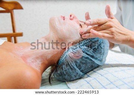 Young and relaxed woman getting a face massage.