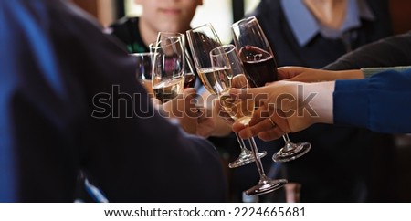 Ringing clinking of glasses at the table in a friendly company after a toast. Celebration of a solemn event or holiday in the family, birthday or wedding. Royalty-Free Stock Photo #2224665681