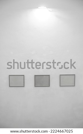 Three squared frames hanging on a wall mockup. 3 white picture frames with wooden border. Group of picture frames on beige wall.