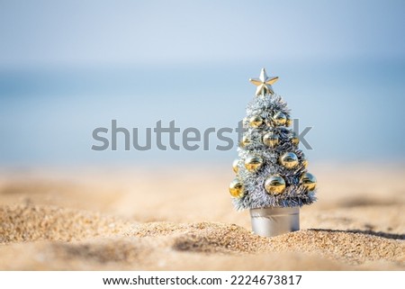 Christmas tree in silver and gold decoration on the beach with blurry background, HAPPY NEW YEAR, copy space, soft focus