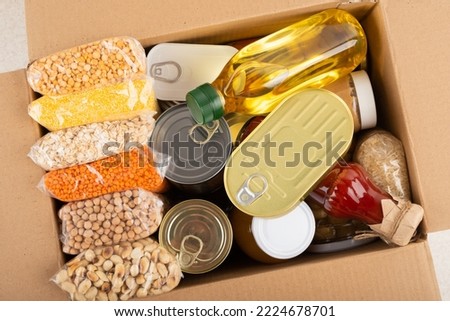 Survival set of nonperishable foods in carton box Royalty-Free Stock Photo #2224678701