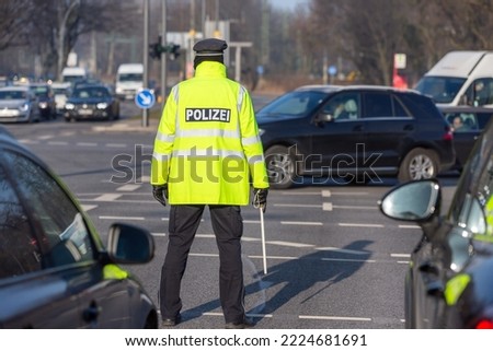 policeman with yellow signal jacket regulates the traffic Royalty-Free Stock Photo #2224681691