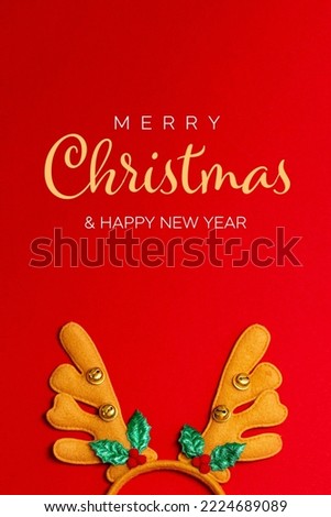 Christmas and New Year greeting vertical card. Fancy headband with horns of a Christmas deer on a red background, text Marry Christmas and Happy New Year