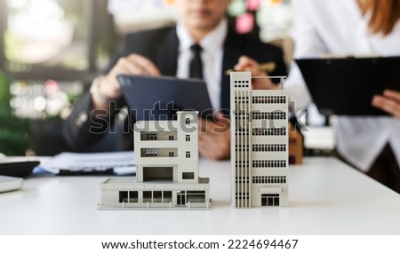 balancing the property sector The real estate agent is explaining the house style to see the house design and the purchase agreement.Wooden house at modern office Royalty-Free Stock Photo #2224694467
