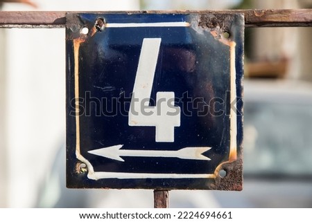 Weathered grunge square metal enameled plate of number of street address with number 4