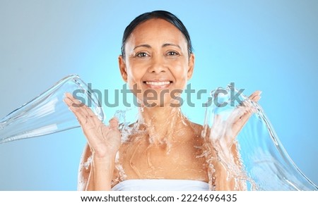 Water splash, woman and beauty portrait on blue background, skincare or facial wellness, body care and shower, cleaning and personal hygiene. Mature studio model, water stream and aesthetic hydration