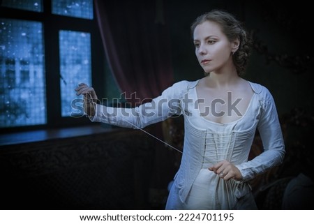 A medieval noble woman is getting dressed in a Scottish costume of the 18th century in a vintage room. Scottish clothing of the 18th century.  Royalty-Free Stock Photo #2224701195